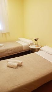 una habitación con dos camas y una mesa con lámpara en SLEEP TURIA apartamentos, en Casinos