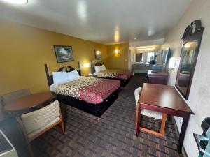 a hotel room with two beds and a desk at Travel inn in Richmond