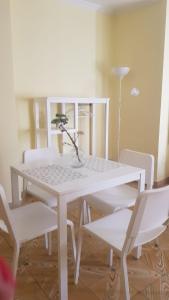 una mesa blanca con sillas blancas y un jarrón con una planta en SLEEP TURIA apartamentos, en Casinos