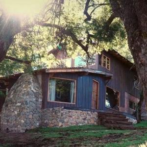ein großes Haus mit einer Steinmauer in der Unterkunft Haras Casa de Campo in San Martín de los Andes