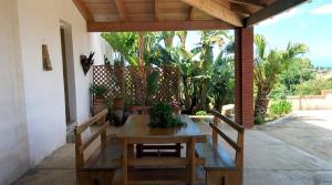 een houten tafel en stoelen op een patio bij Il Gelsomino Home Holiday in Alcamo