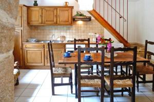 a kitchen with a wooden table with chairs and a sink at Charming stone house with shared pool, Chambonas in Chambonas +5 photos
