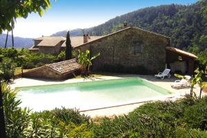a small swimming pool in front of a house at Charming stone house with shared pool, Chambonas in Chambonas