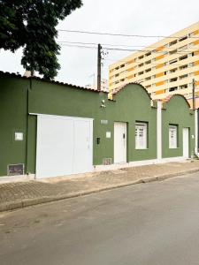 un edificio verde al lado de una calle en CASA HOTEL PIRACICABA, en Piracicaba