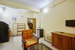a living room with a chair and a flat screen tv at Saikunj Holiday Homes in Candolim