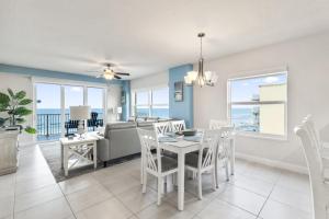 a dining room and living room with a table and chairs at A Wave From it All Oceanfront Pool Condo in Daytona Beach