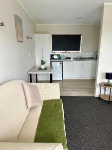 a living room with a white couch and a tv at Bay Lodge Motel in Tauranga