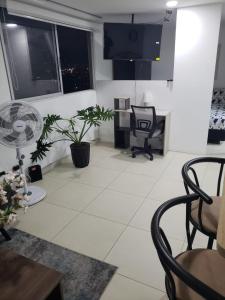 a living room with white tile floors and windows at Apartamento en medio de la Naturaleza in Medellín