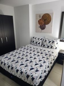 a small bedroom with a bed with a comforter at Apartamento en medio de la Naturaleza in Medellín