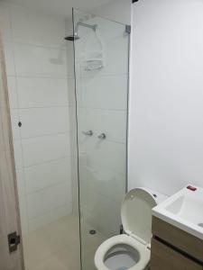 a bathroom with a toilet and a glass shower at Apartamento en medio de la Naturaleza in Medellín