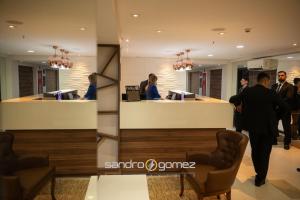 a group of people standing around a reception desk at Hellix Flat Itaboraí in Itaboraí