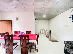 a dining room with a red table and chairs at Gurty House in Weligama