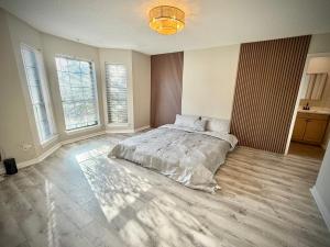 a bedroom with a large bed and two windows at Charming 3-bedroom house in delightful Lewisville with AC, WiFi in Lewisville