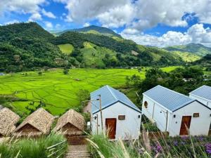 a group of houses with mountains in the background at บ้านไม่ไผ่บ้านเวร-BambooHouse Banwen in Ban Khun Nam Nan