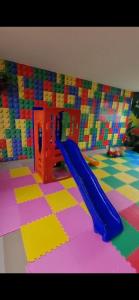 a playground with a blue slide in a room at APP 2 Quartos Belle Nature in Valparaíso de Goiás