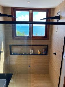 a bathroom with a shower with a window at Casa de condomínio na praia de cototelo com bela vista para o mar in Parnamirim +30 photos