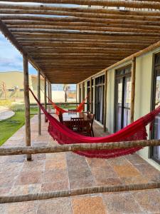 a hammock on the patio of a house at Encanto Moanara in Luis Correia