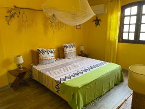 Rivière-SaléeVilla Manguier的黄色间内一间卧室,配有一张床