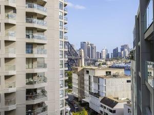 悉尼1 Stop to CBD - 3 Mins Walk Train - Milsons Point的一座高大的白色建筑,以城市为背景