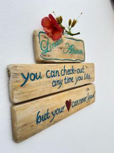 a sign that says you can check out any time you like at Lindos Athena in Lindos