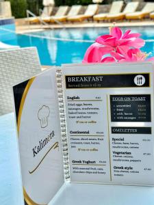 a menu for a restaurant next to a swimming pool at Lindos Athena in Lindos