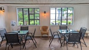 a dining room with tables and chairs and windows at La Gentilhommière in Saint-Siméon