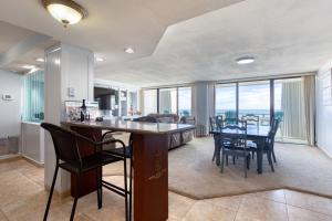 a kitchen and dining room with a table and chairs at Aliki Atrium Beachfront Condo in Ormond Beach