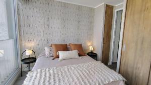 a bedroom with a large bed with two lamps at Encantador departamento en Barrio Ñuñoa in Santiago