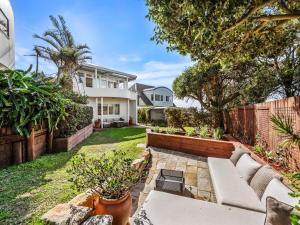 a backyard with a bench and a fence at Coastal Dream BeachFront Oasis in Newcastle