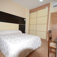 a bedroom with a white bed and a chair at Casa Rural Virgen de las Cruces in Daimiel