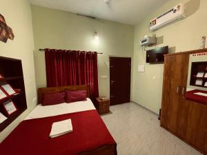a bedroom with a bed with a red blanket at MO’s Agro in Pāppinisseri