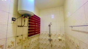 a bathroom with a shower and a red stripe on the wall at Apartment Diamant in Cotonou +9 photos