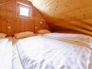 a large bed in a wooden cabin with a window at Holiday home in Gaal im Murtal in a beautiful setting in Pirkach