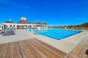 a swimming pool with chairs and a building at 6156 - Family Tides in Nags Head