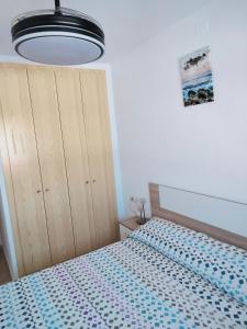 una camera con un letto e una grande luce di Piso a 3 minutos de la playa a Puerto de Mazarrón