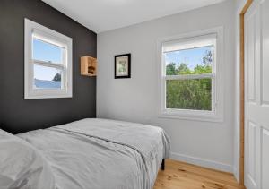 una camera da letto con un letto e due finestre di La Bellevue ocean views, nice sandy shore beach a Grande-Digue