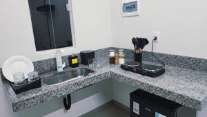 a bathroom counter with a sink and a mirror at Suítes Caminho do Pantanal in Aquidauana +25 photos