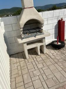 a stone pizza oven sitting on top of a patio at Neiras Apartments Blagaj in Blagaj