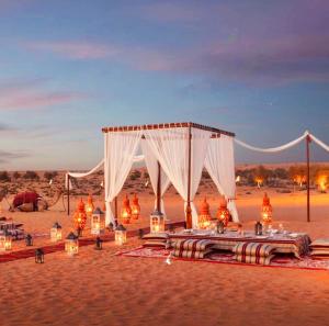 Una tienda de campaña en el desierto con velas y luces. en Desert Sam Dunes Camp, en Sām