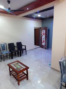 Habitación con sillas, mesa y puerta en Aashirwad apartment, en Panchgani