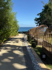 a pathway with a fence and the ocean in the background at 8 Newtown Mactan Condominium in Lapu Lapu City