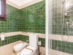 a green tiled bathroom with a toilet and a shower at Holiday Home in Carlentini with Swimming Pool,Garden,Terrace in Agnone Bagni