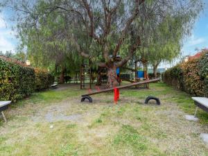 a park with a tree and a playground at Holiday Home in Carlentini with Swimming Pool,Garden,Terrace in Agnone Bagni
