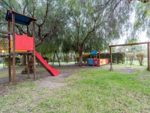 a playground with a red slide in a park at Holiday Home in Carlentini with Swimming Pool,Garden,Terrace in Agnone Bagni