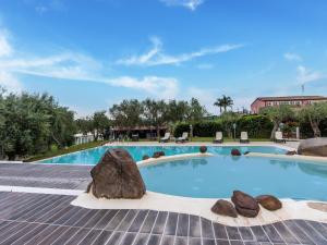 a large swimming pool with rocks in the middle at Holiday Home in Carlentini with Swimming Pool,Garden,Terrace in Agnone Bagni