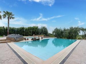 a large swimming pool with blue water at Holiday Home in Carlentini with Swimming Pool,Garden,Terrace in Agnone Bagni