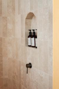 a bathroom with two bottles on a wall at Stone - Rare Earth Retreats in McLaren Vale +12 photos