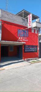 a red building with a sign on the side of it at Posada Casa Blanca in Cedro