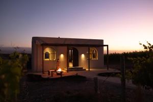 a small house with a woman sitting in front of it at Stone - Rare Earth Retreats in McLaren Vale