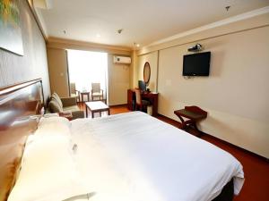 西安市にあるGreenTree Inn Xi'an Bell and Drum Tower Food Street Ancient City Wall Ximen Express Hotelのベッドルーム(大きな白いベッド1台、テレビ付)